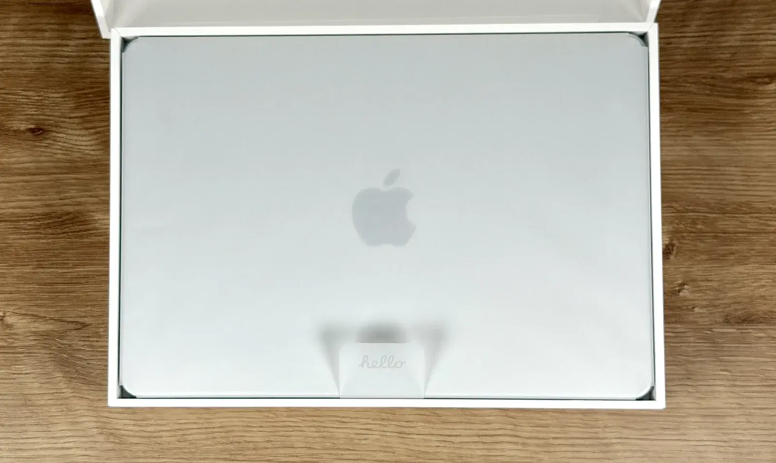 MacBook Neoの箱を開けた様子。Appleロゴが映えるシルバーの天板