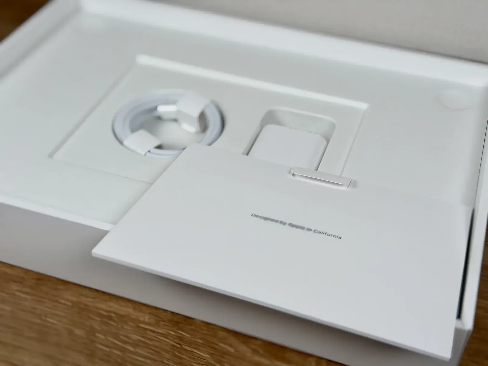 MacBook Neoの付属品。USB-Cケーブルと説明書が収まっている