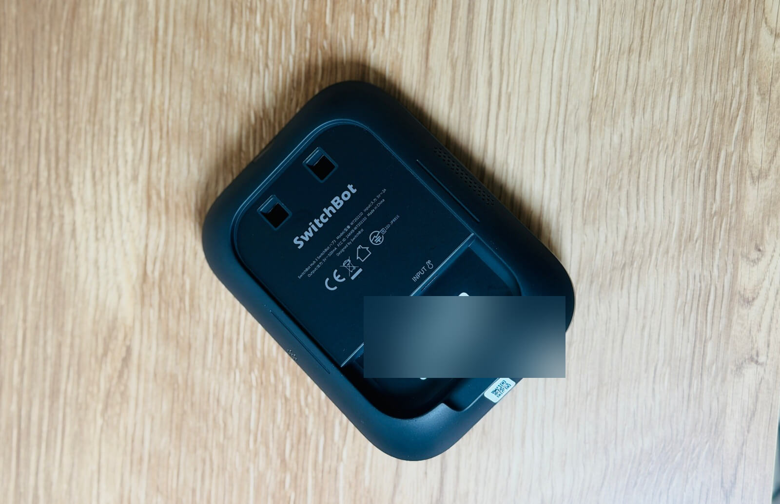 本体裏面とスタンド(QRコードラベルはぼかし処理しています)。ケーブル取り回しのスリットが背面に用意されている