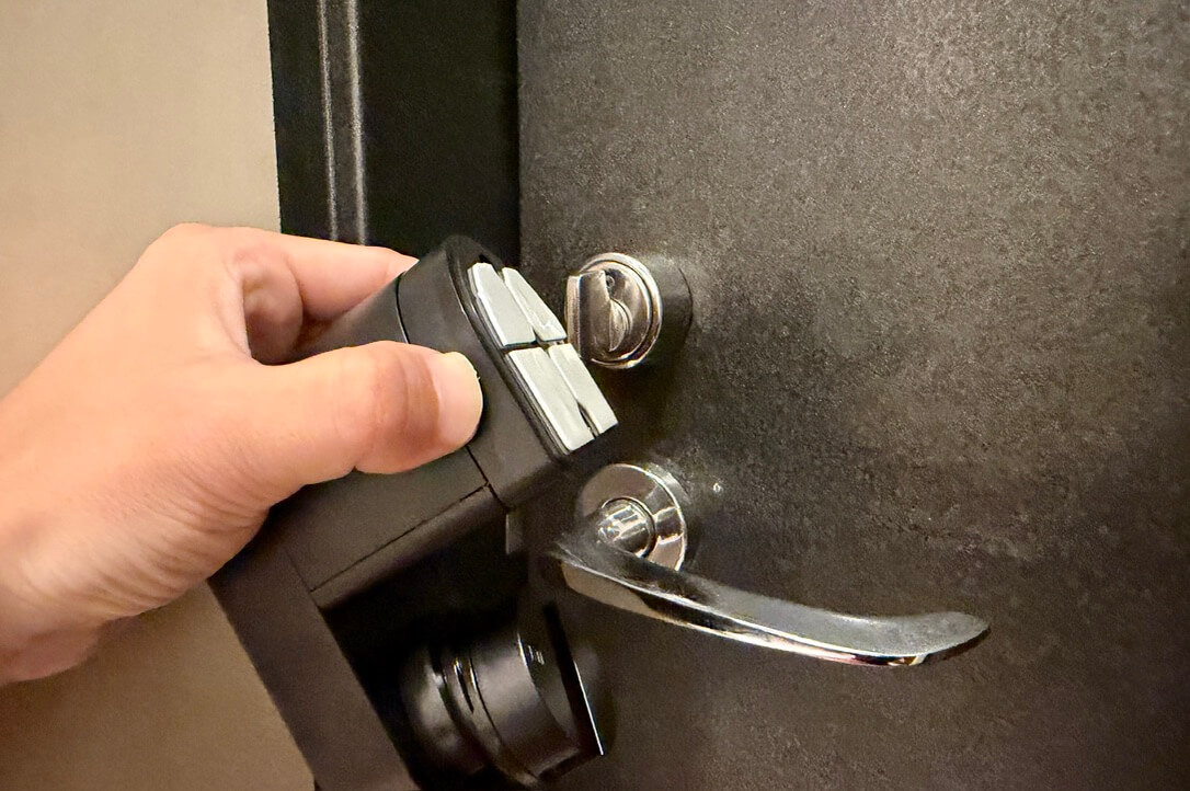 Nature Lock本体をドアへ貼り付ける様子
